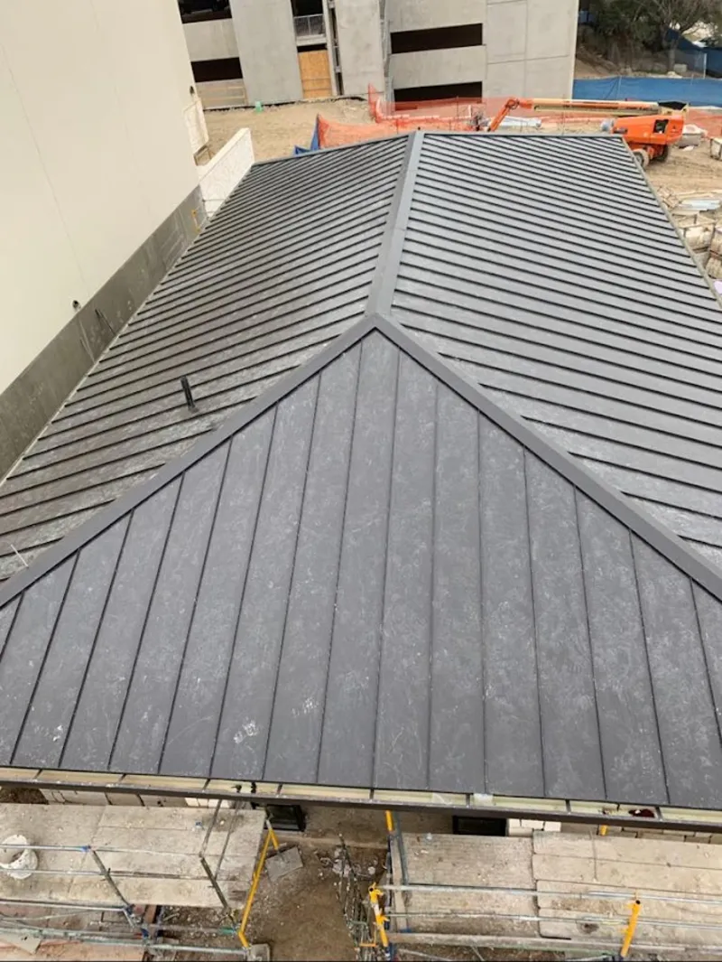Commercial metal roof construction with crane equipment in Berthoud